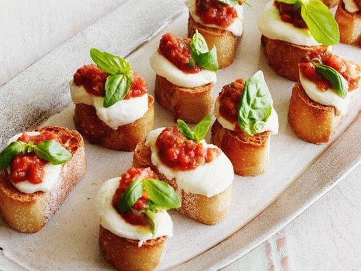 Photo of Bruschett with tomatoes, mozzarella and basil