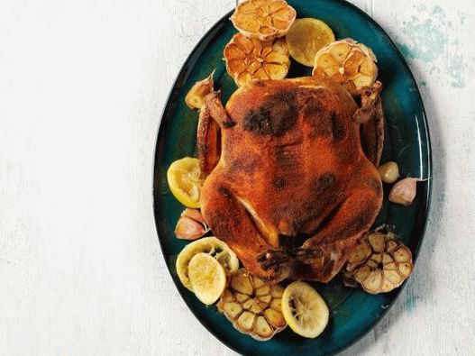 Photo Spiced whole chicken with baked garlic and lemons