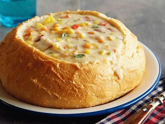 Photo of a chowder with corn and cheese in bread bowls