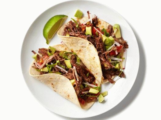 Photo Beef for tacos stewed with green salsa in a slow cooker