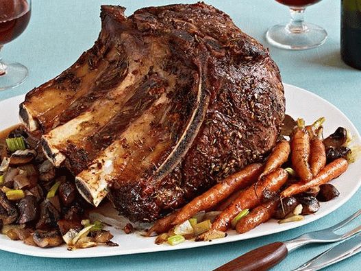 Photo Beef loin on a bone in the oven with vegetables