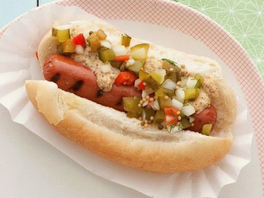 Photo Hot dog with grilled sausage and homemade pickled cucumber sauce