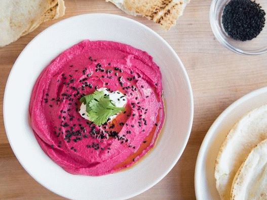 Garnish beet hummus with yogurt and sesame seeds