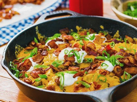 Photo grilled potatoes with cheese and sour cream, fried in a pan