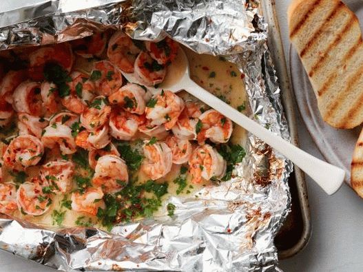 Photo of grilled scampi shrimps in a foil bag