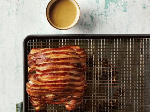 Photo of chicken in the oven wrapped in bacon