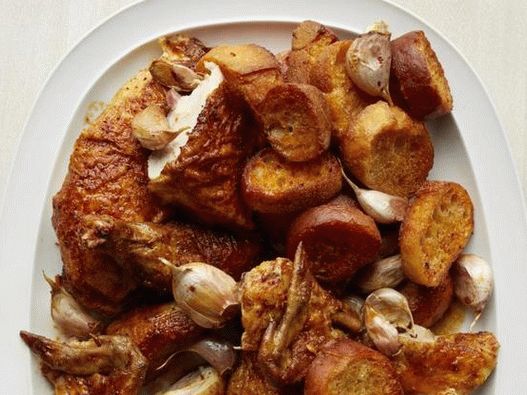 Photo Chicken baked in the oven whole with baked garlic and paprika