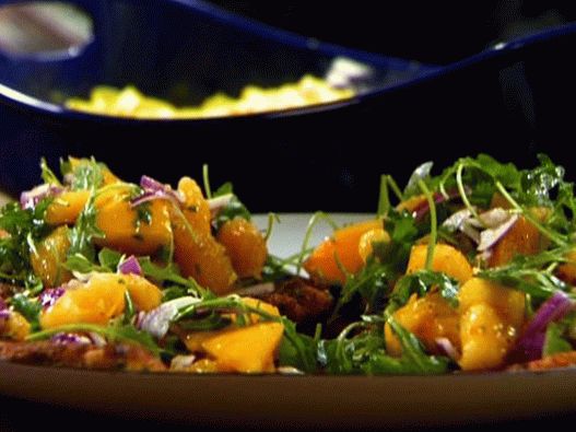 Photo of a chicken chopped cheese breading with arugula and oranges