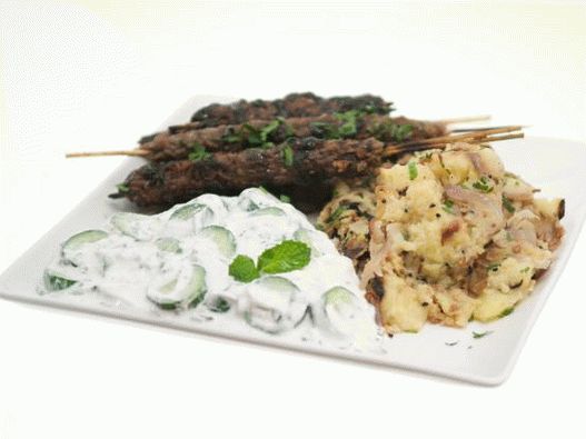 Photo of Kufta of lamb on skewers with pomegranate glaze, potatoes with Bengal spices and raita sauce