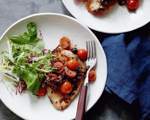 Chicken breast fried in a pan with tomato and olive sauce
