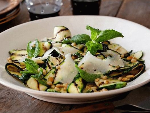 Grilled zucchini salad with vinaigrette sauce with lemon and herbs, cheese and pine nuts