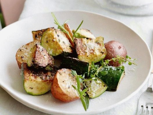 Zucchini and potatoes baked with cheese under the grill