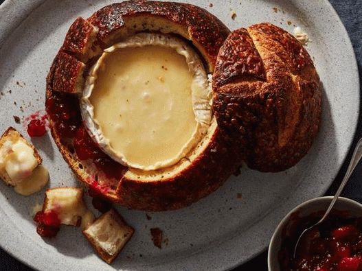 Bread bowl stuffed with brie cheese and cranberry sauce