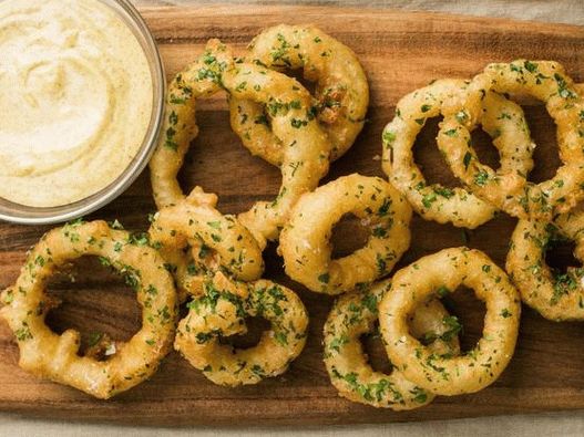 Photo Onion rings in beer batter with mustard dip