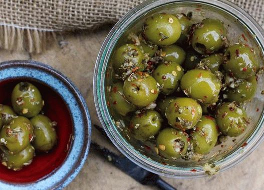 Photo Pickled olives with rosemary, red chili, orange and paprika