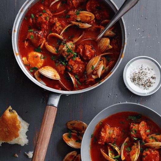 Photo Mussels stewed in a pan in tomato sauce