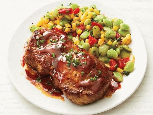 Photo Natural pork cutlets in a sharp glaze with a salad of sukkotash