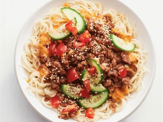 Photo Spicy noodles with minced pork, vegetables and sesame seeds