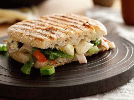 Photo of a Panini with turkey, romaine lettuce, eggs and blue cheese