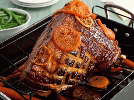 Photo Easter ham in tangerine glaze with young carrots