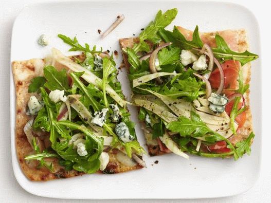 Photo Pizza on pita bread with ham and arugula