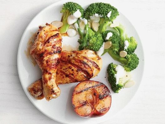 Photo Spicy chicken with grilled plums and stewed broccoli on a side dish