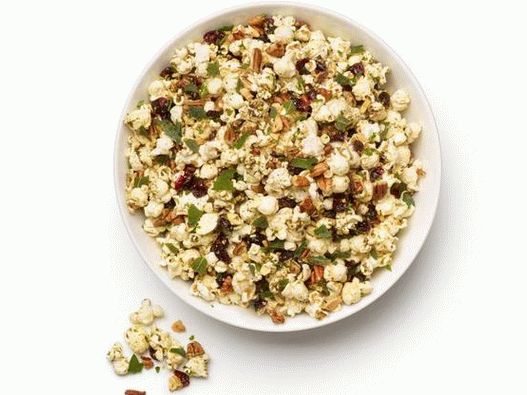 Photo Spiced popcorn with nuts, herbs and dried cranberries
