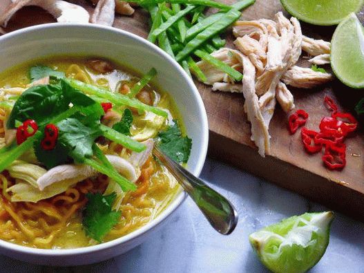 Photo Spicy coconut milk soup with curry and noodles
