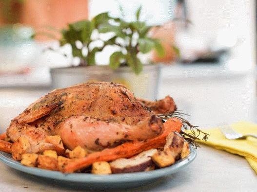 Chicken with aromatic herbs and baked root vegetables in the oven