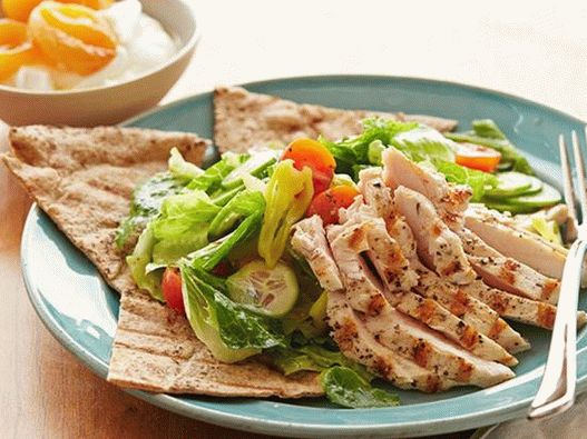 Salad with grilled chicken and dried apricots on a Greek cake