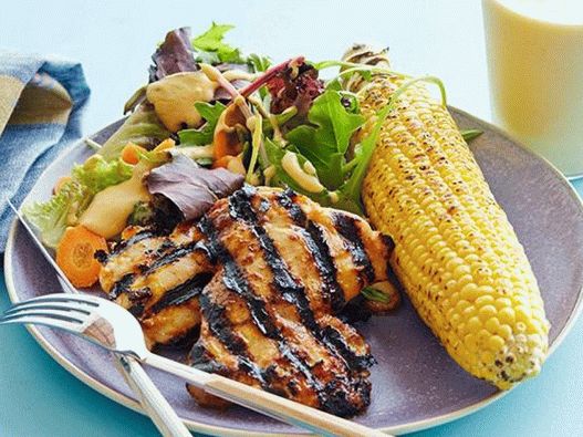 Chicken in barbecue sauce with salad leaves, grilled corn and smoothie