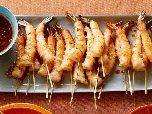 Fried shrimp on skewers with soy sauce, fresh ginger and toasted sesame seeds