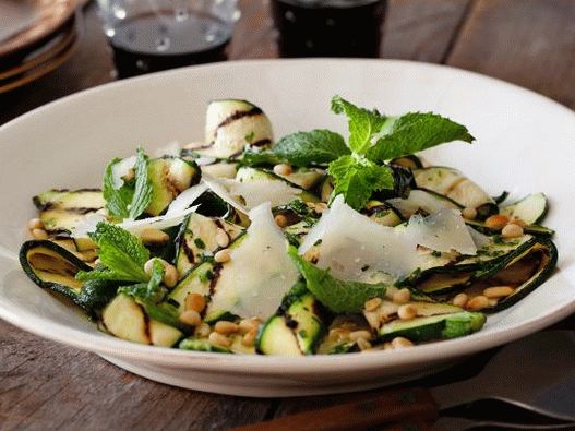 Photo Grilled zucchini salad with vinaigrette sauce with lemon and herbs, cheese and pine nuts