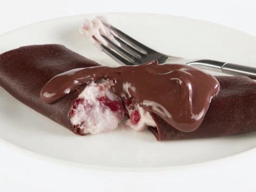 Photo Chocolate pancakes with curd and strawberry filling