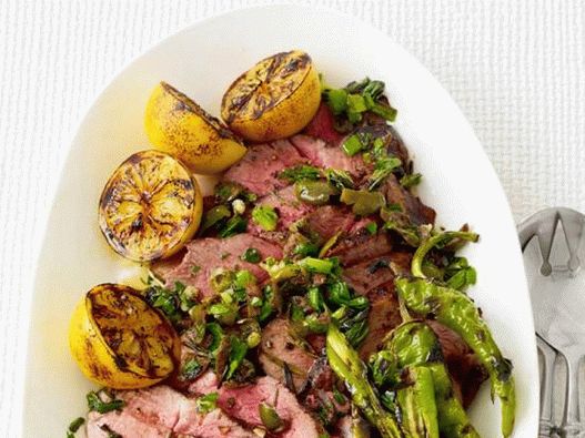 Photo Skirt steak with lemons, hot pepper and green onions on the grill