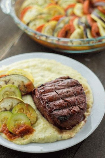 Photo Beef tenderloin steak with side dish of polenta with blue cheese