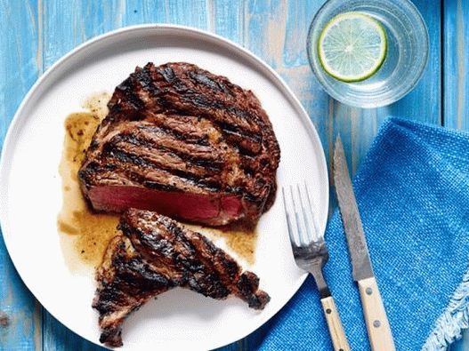 Photo of Striploin steaks on charcoal