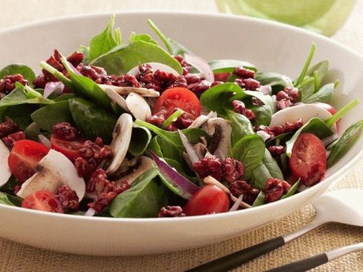 Photo Super-healthy spinach salad with walnuts in pomegranate glaze