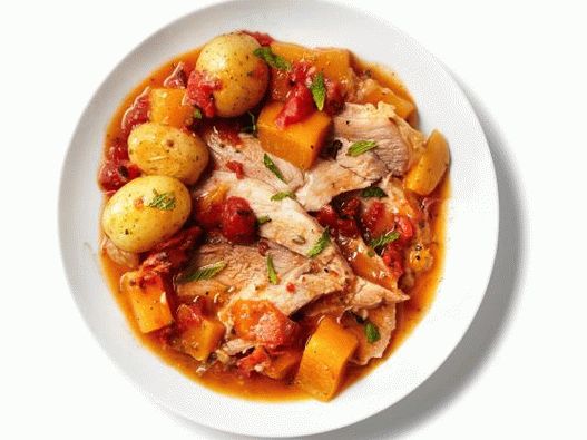 Photo Pork shoulder stewed with root vegetables and coriander in a slow cooker