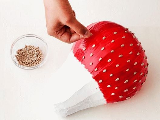 Mix food coloring and vanilla extract in a small bowl, coat the cake, then arrange the sunflower seeds in rows to simulate strawberry seeds