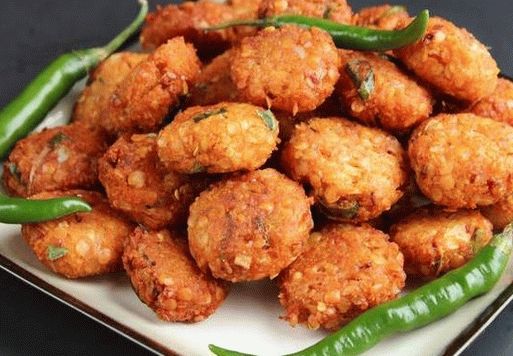 A photo of Wadai from a vat gave (deep-fried donuts from yellow chopped peas with dill)