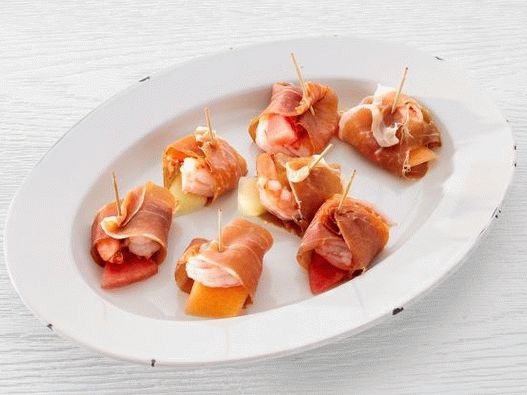 Photo Appetizer of melon and shrimp wrapped in prosciutto ham