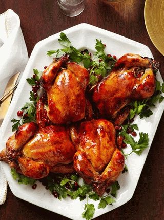 Photo Baked chickens in pomegranate glaze stuffed with rice