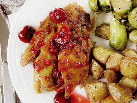 Photo Baked duck with a crispy crust in cherry-rosemary sauce