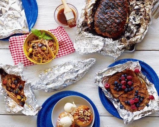 Photo Healthy dishes on the grill in foil envelopes