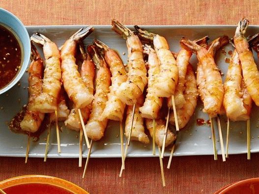 Photo Fried shrimp on skewers with soy sauce, fresh ginger and toasted sesame seeds