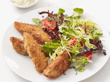 Photo of fried chicken breast in breadcrumbs with salad